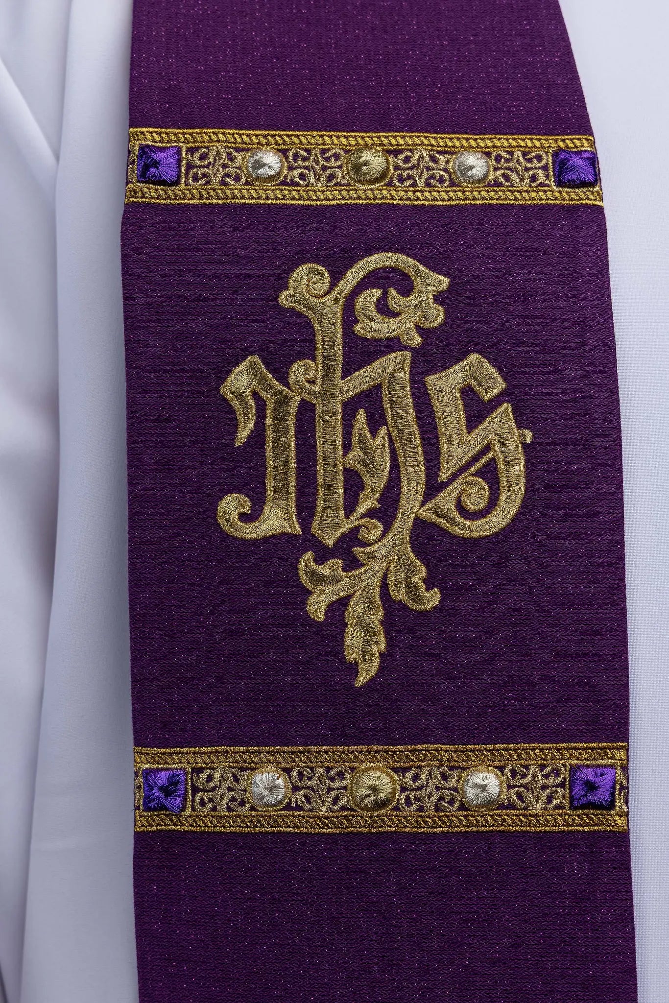 Purple Advent stole with gold IHS embroidery and Advent candle motif, made from shimmering fabric.