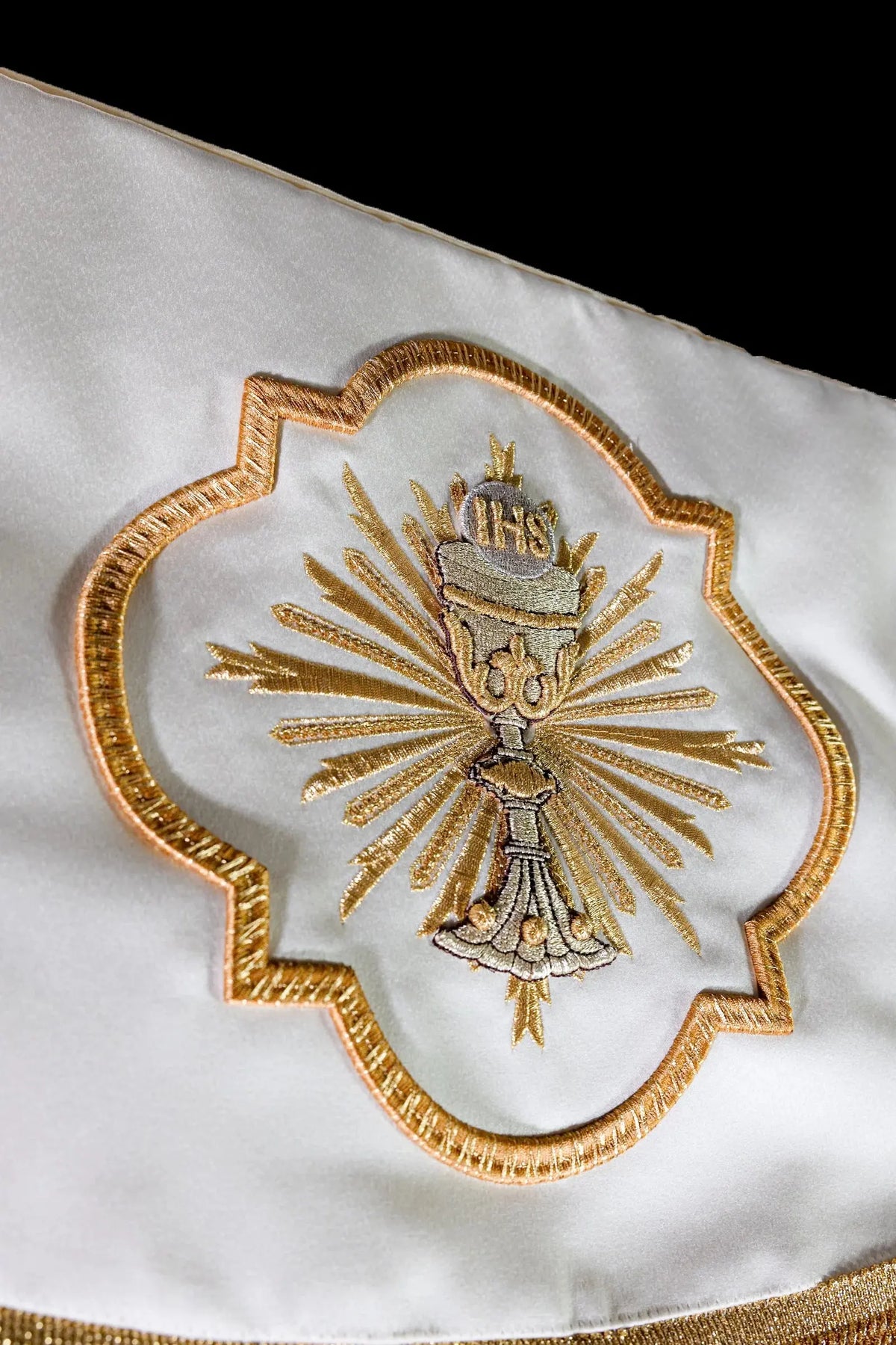 White baldachin with embroidered chalice and altar bread, close-up view