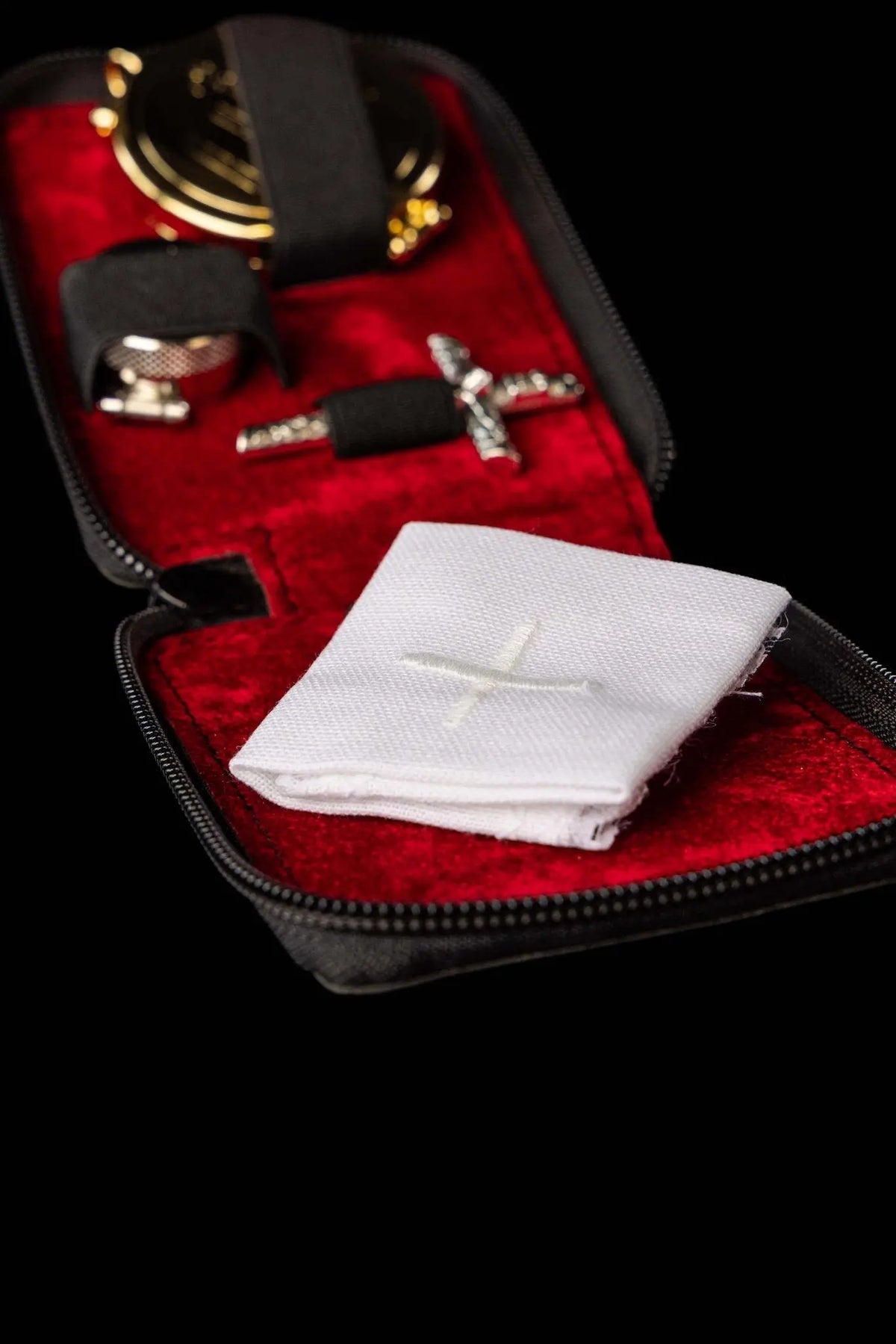 Czarna bursa liturgiczna z krzyżem i białym korporałem, otwarta