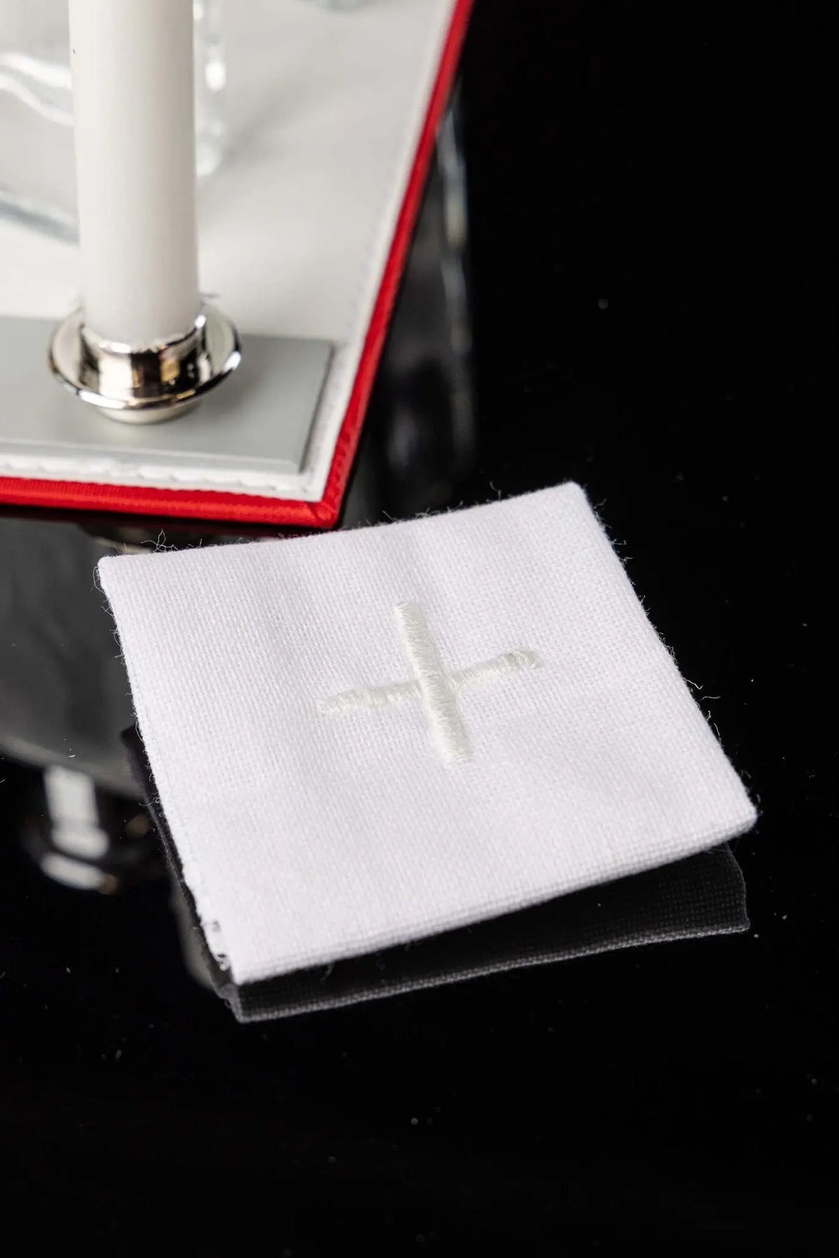 Biała walizka na misje z wyposażeniem liturgicznym z haftowanym krzyżem, zbliżenie