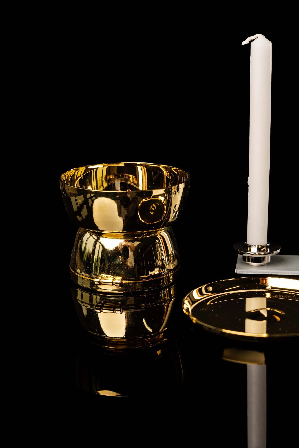 Złote naczynie liturgiczne i biała świeca z zestawu walizki, widok szczegółu