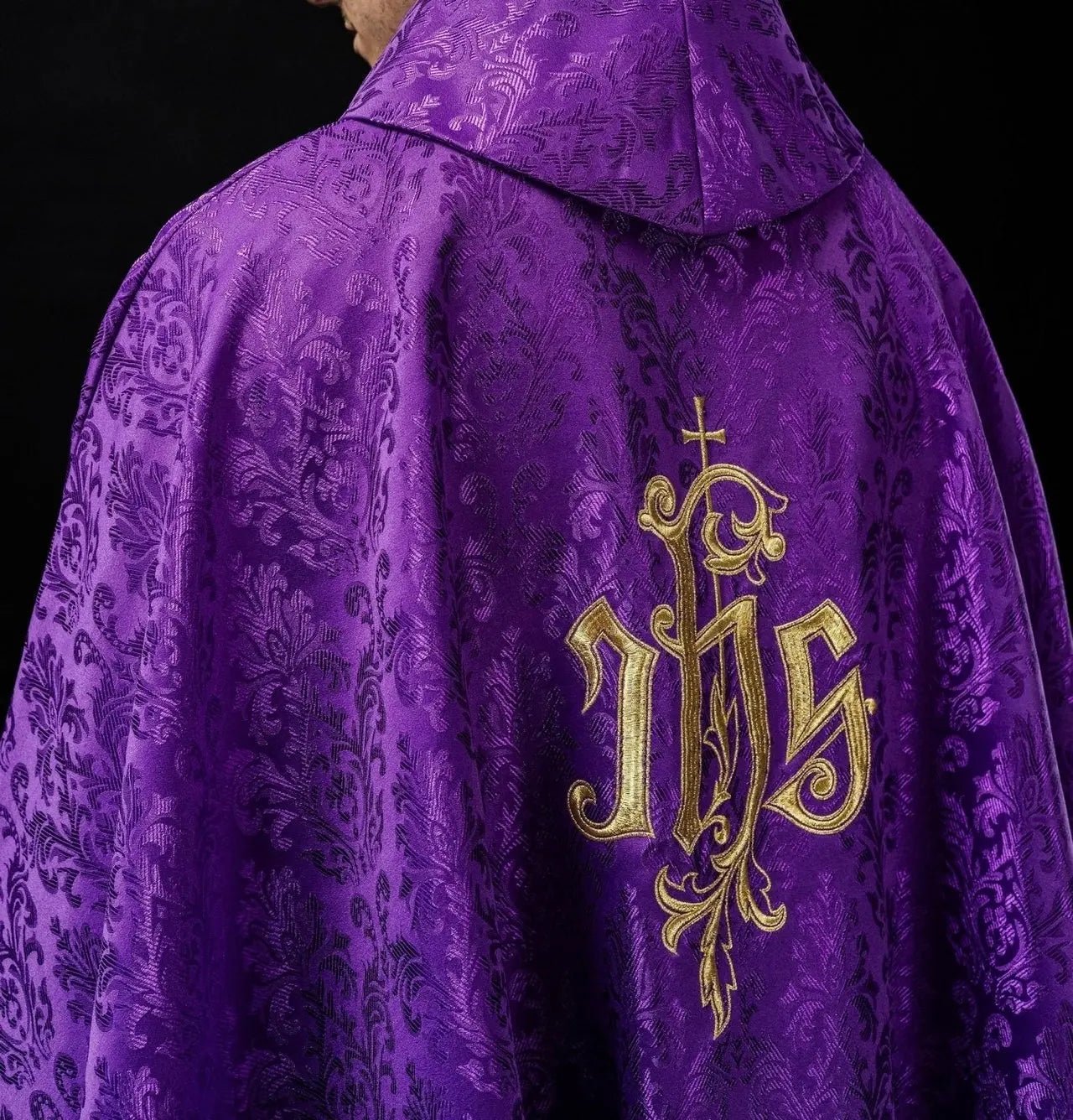 Fioletowy ornat liturgiczny z haftowanym motywem IHS na ozdobnej tkaninie