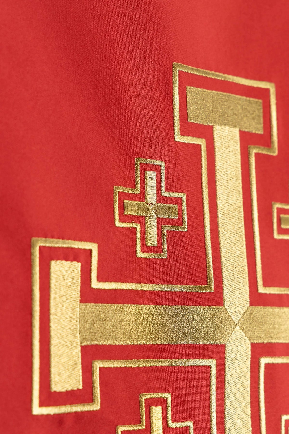 Czerwona serweta na lektorium z haftem Krzyża Jerozolimskiego, zbliżenie lewej części motywu