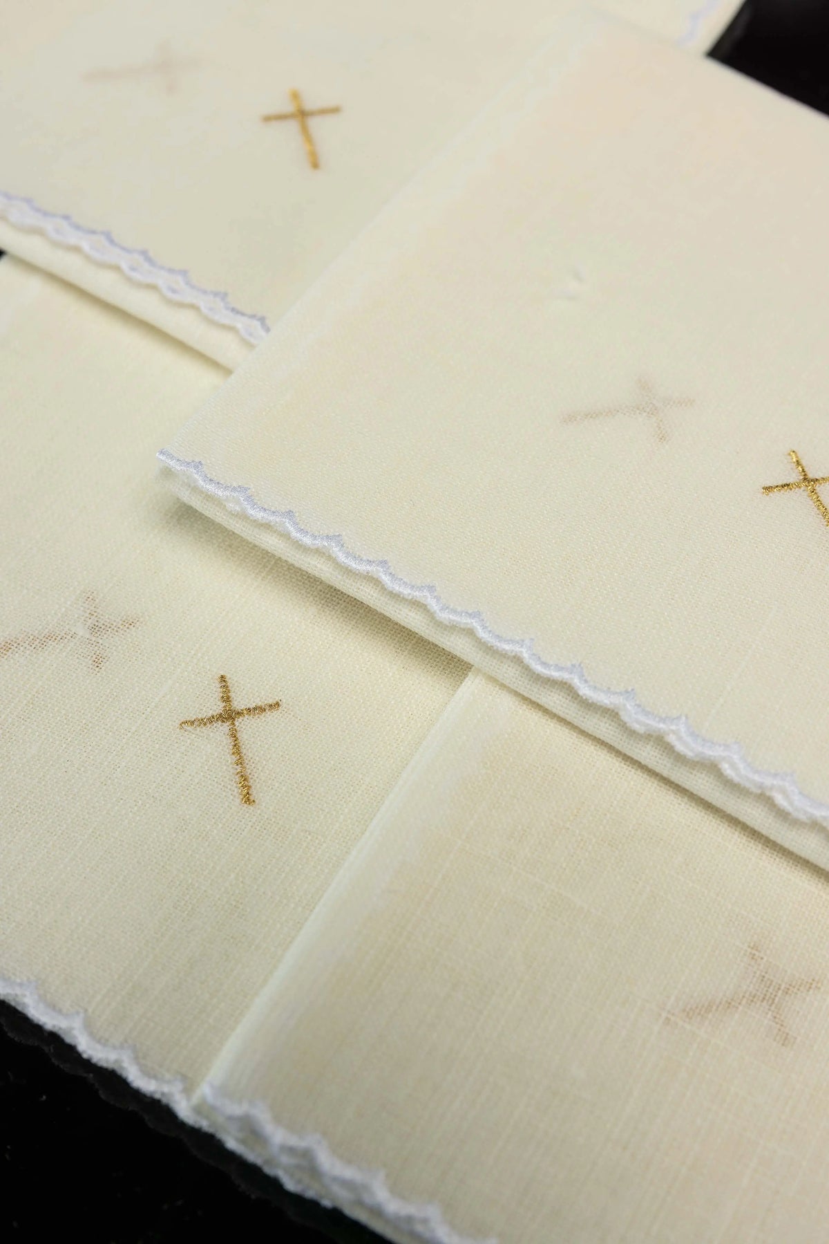 Ecru korporały liturgiczne z haftem złotego krzyża, zbliżenie haftu