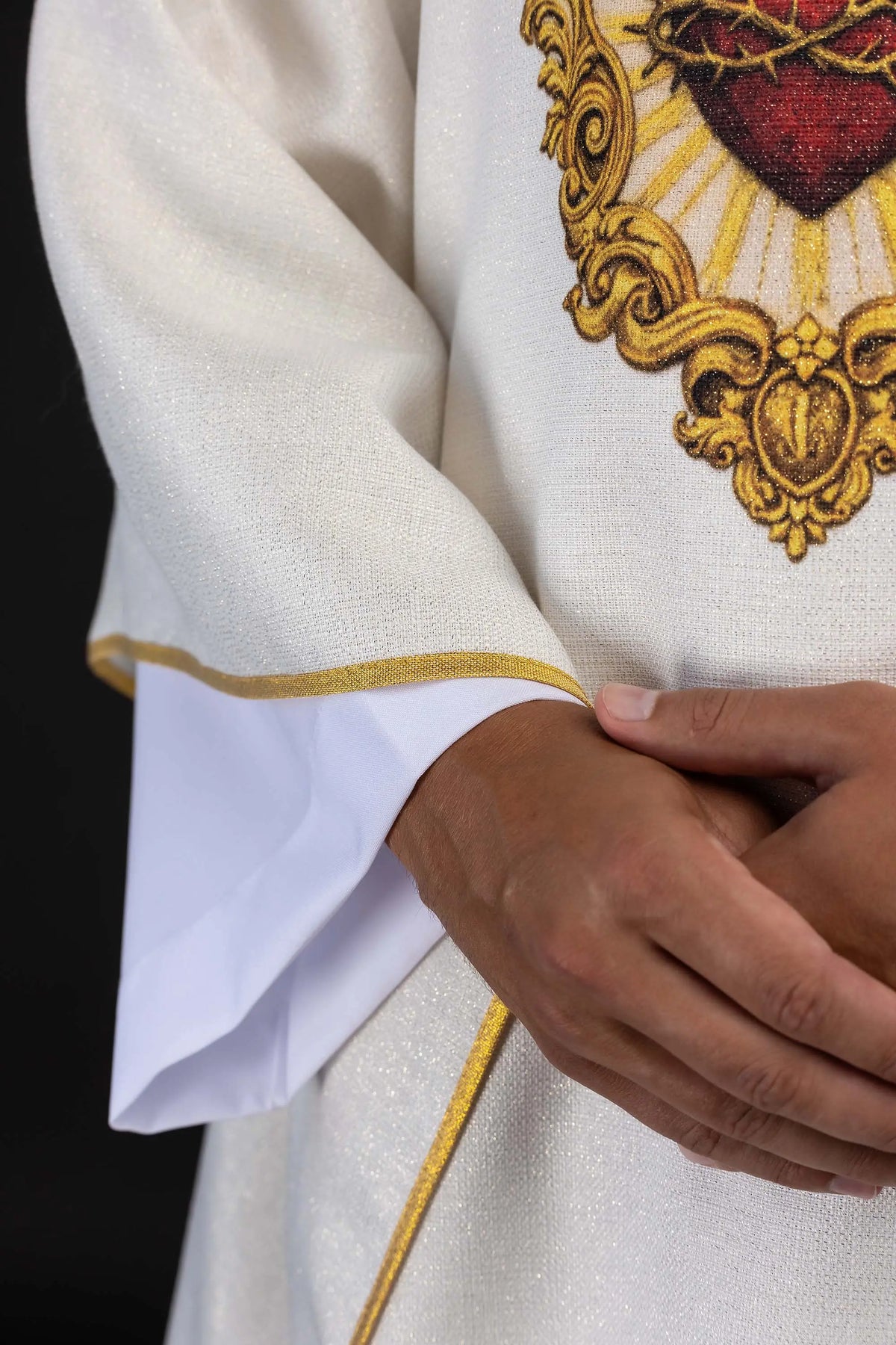 Biały ornat z Najświętszym Sercem Pana Jezusa, zbliżenie złotego lamowania rękawa