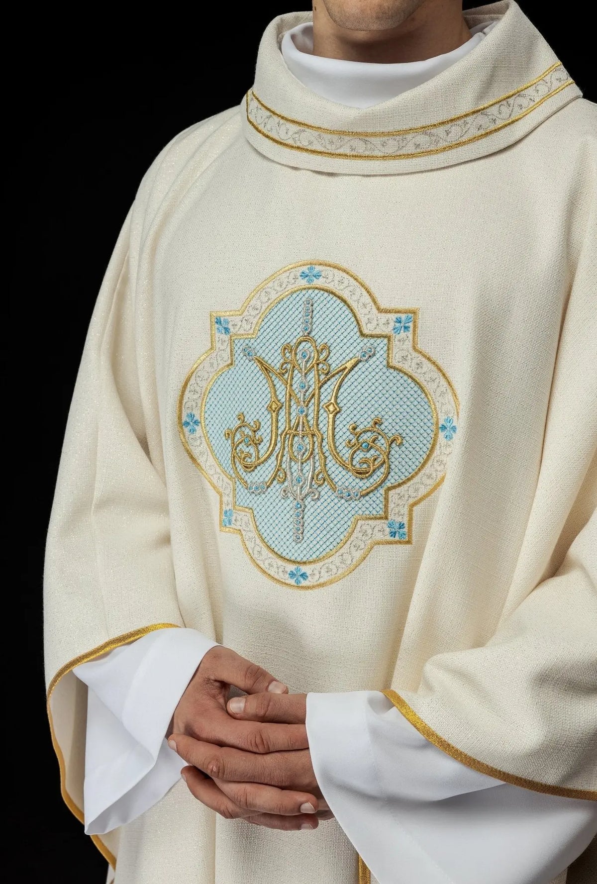 Ecru ornat maryjny z haftowanym herbem Maryjnym, zbliżenie haftu z przodu