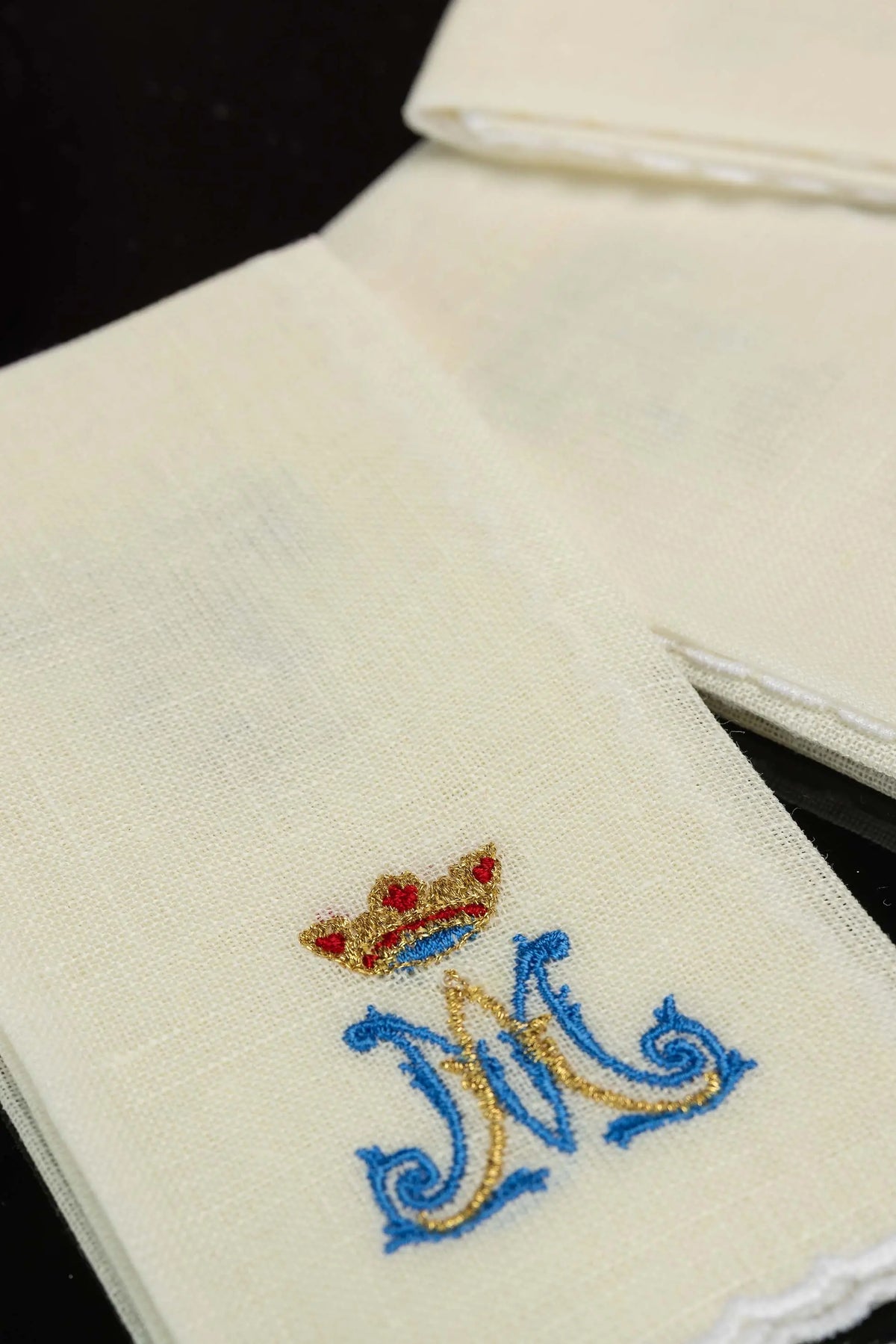 Ecru puryfikaterz liturgiczny z haftem monogramu i koroną, zbliżenie