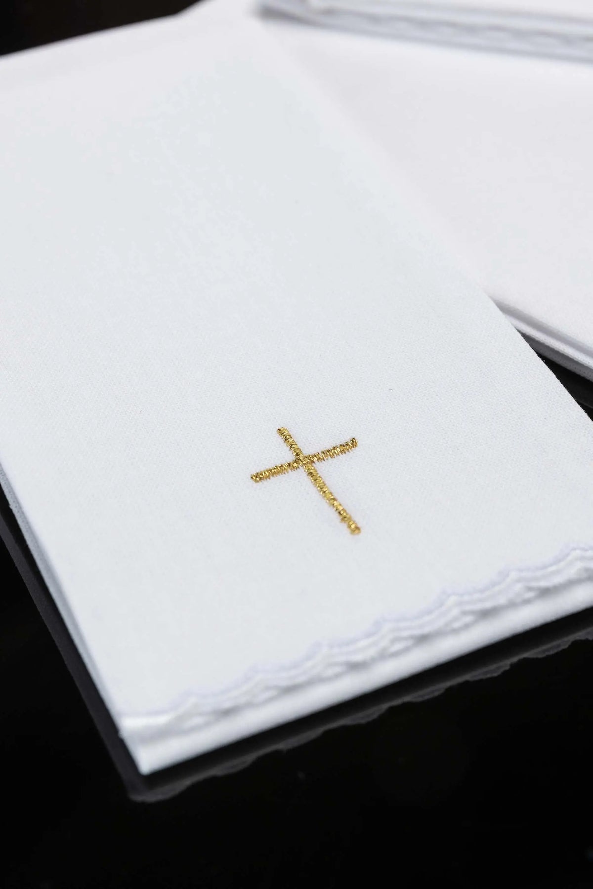 Biały puryfikater liturgiczny ze złotym krzyżem, zbliżenie haftu i wykończenia