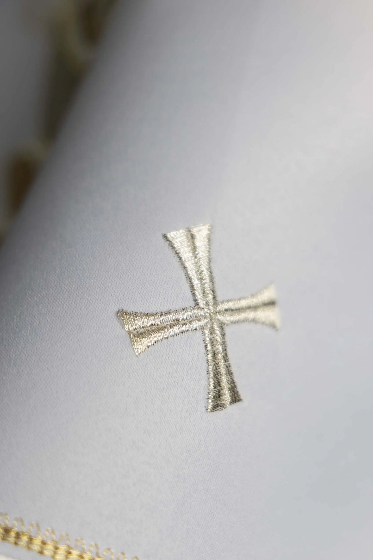 Biały welon na puszkę z haftem krzyża, zbliżenie
