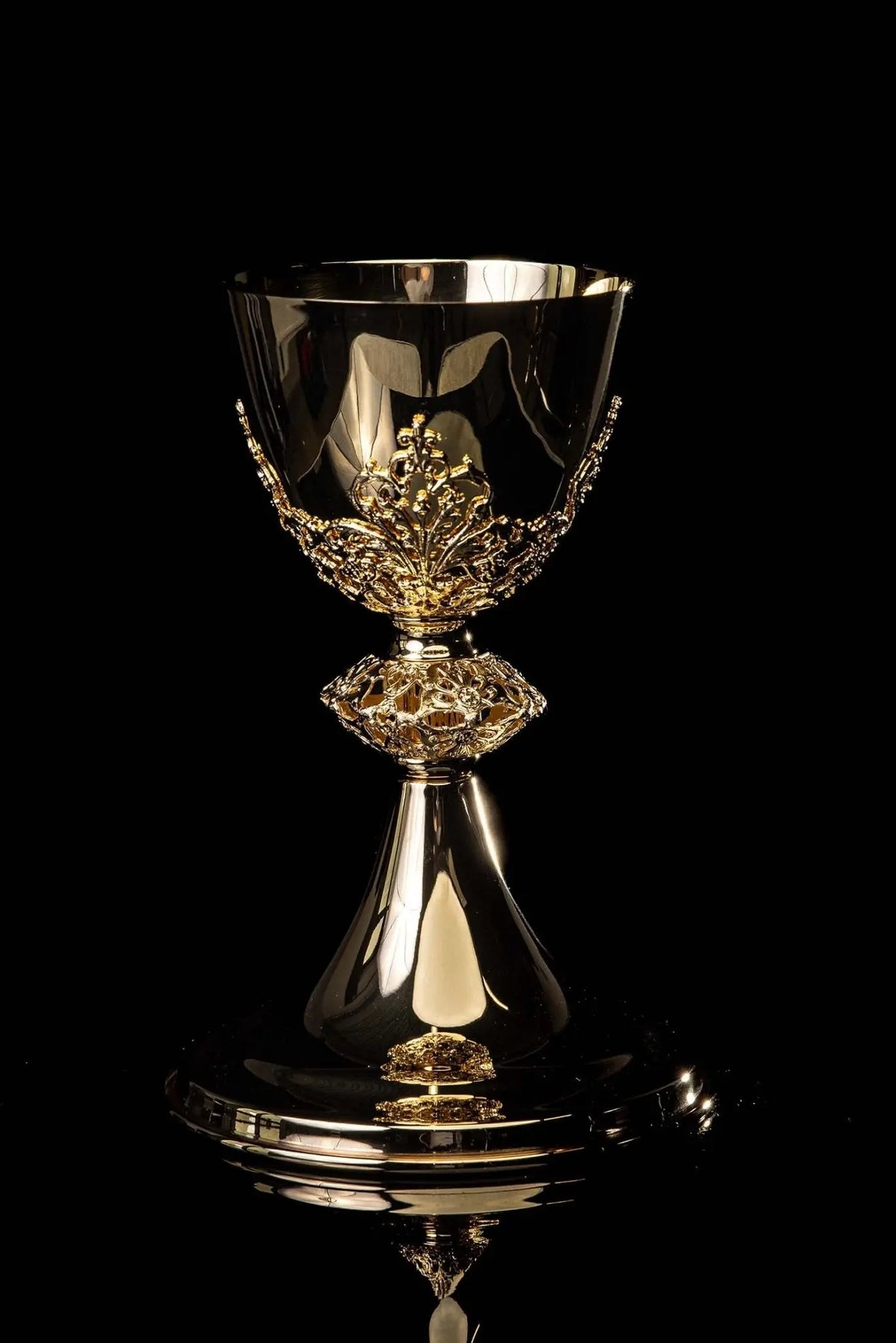 Złoty kielich mszalny do celebracji Eucharystii z roślinnym ornamentem, widok z przodu