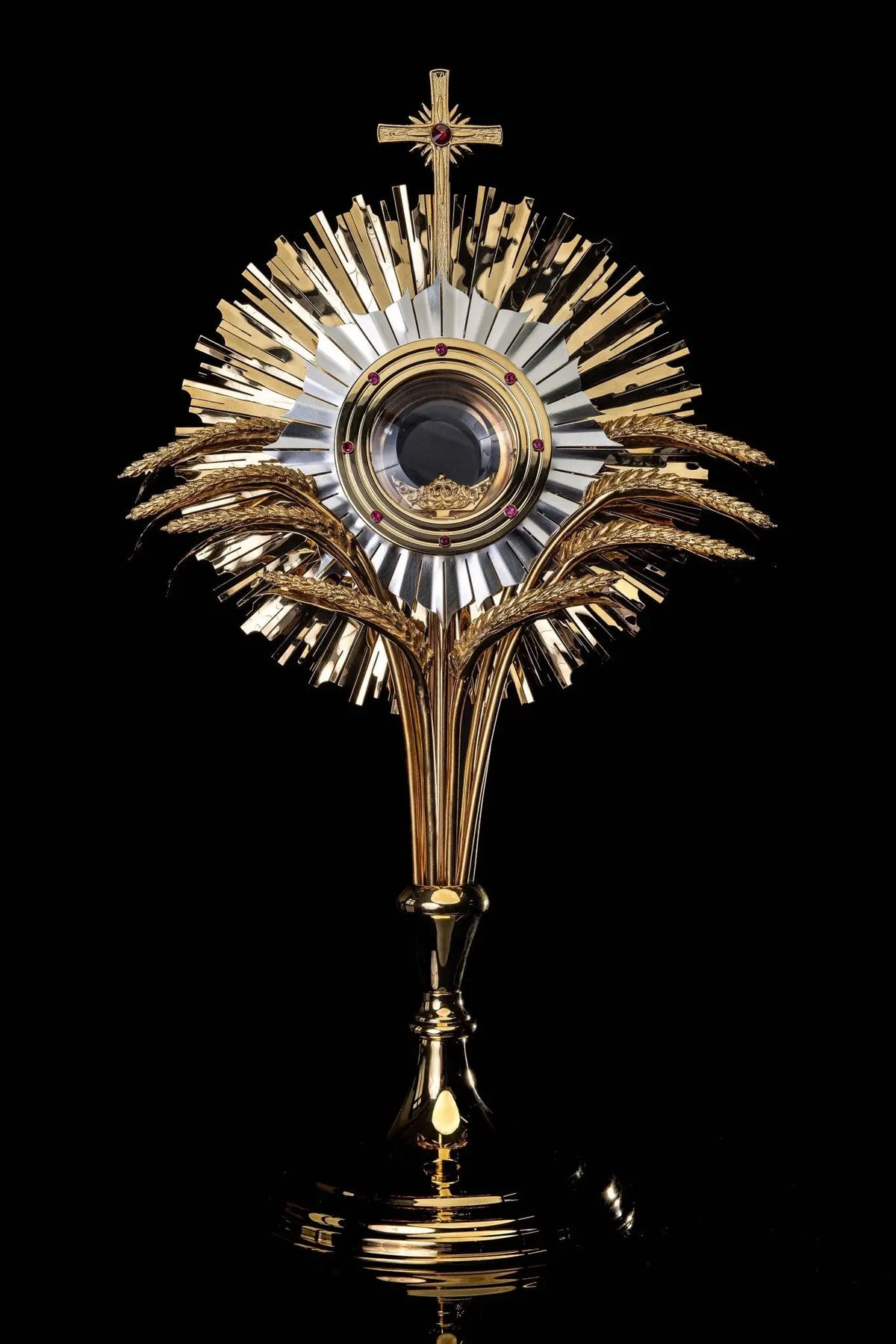 Złota monstrancja na adorację eucharystyczną z motywem kłosów i rubinowymi zdobieniami, widok z przodu