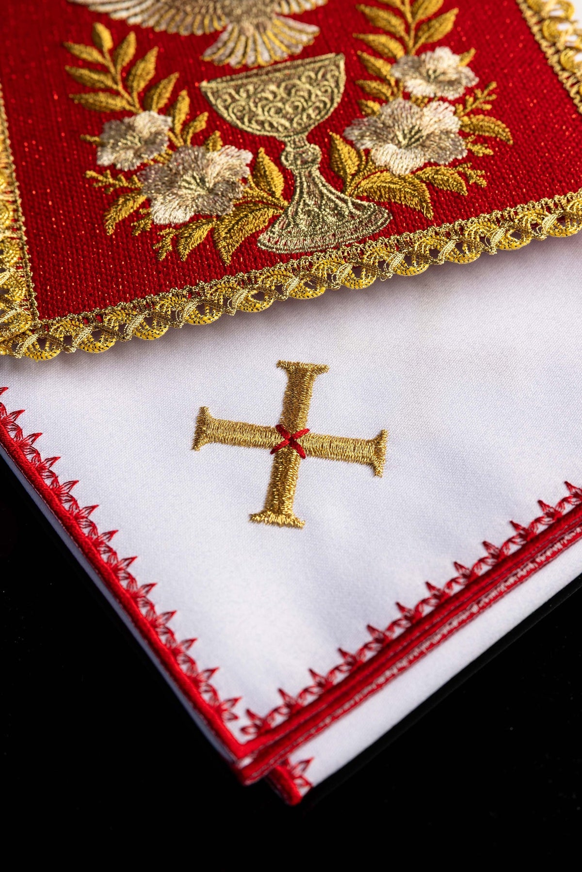Biała bielizna kielichowa z haftowanym krzyżem, zbliżenie obszycia
