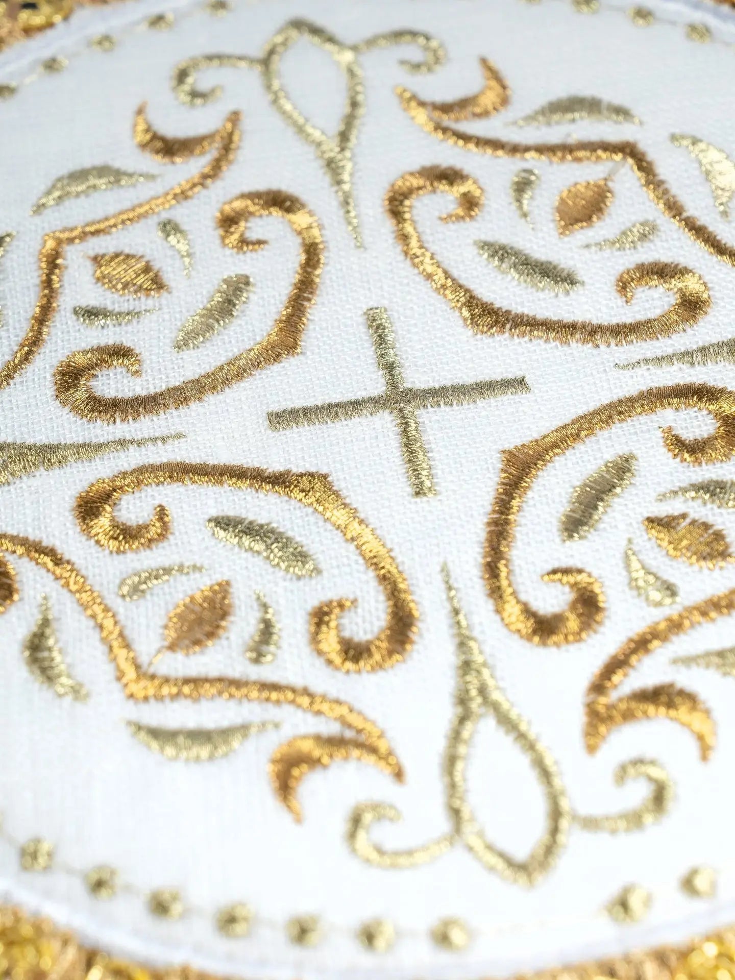 Linen cup set with a cross motif on a round palle surrounded by rich embroidery