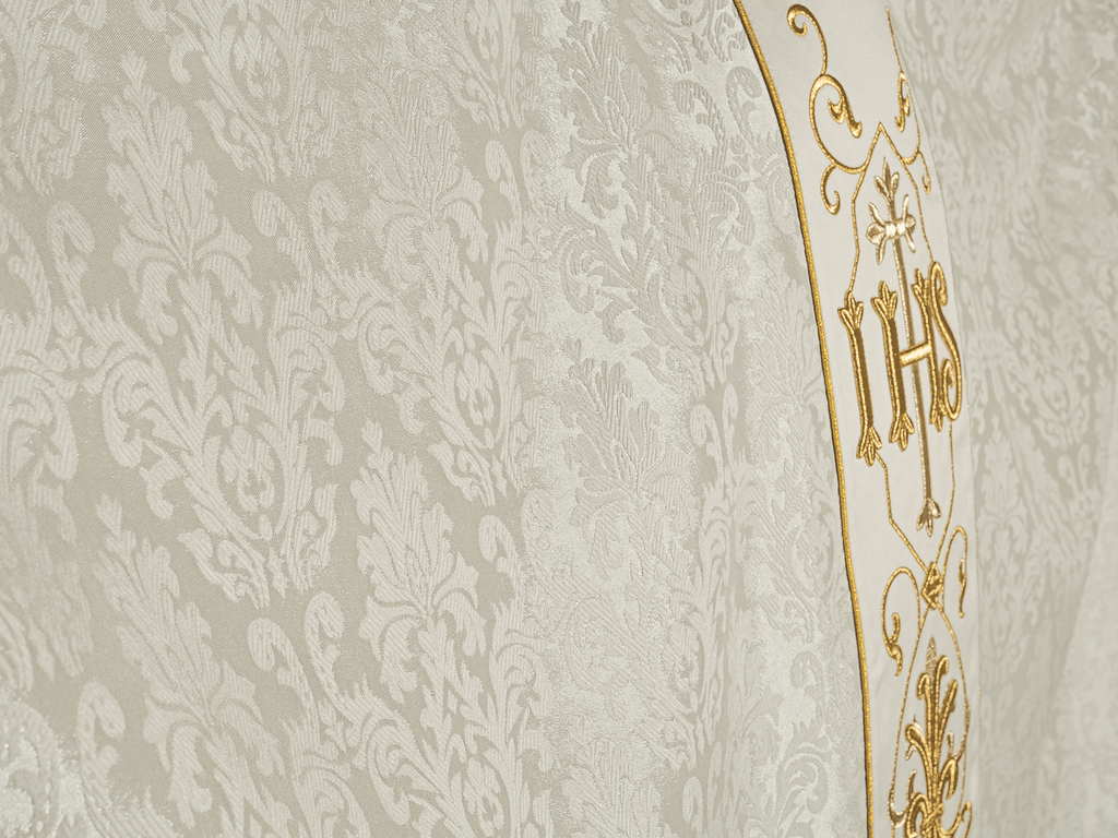 Ornat ecru haftowany na ozdobnej tkaninie z symbolem IHS