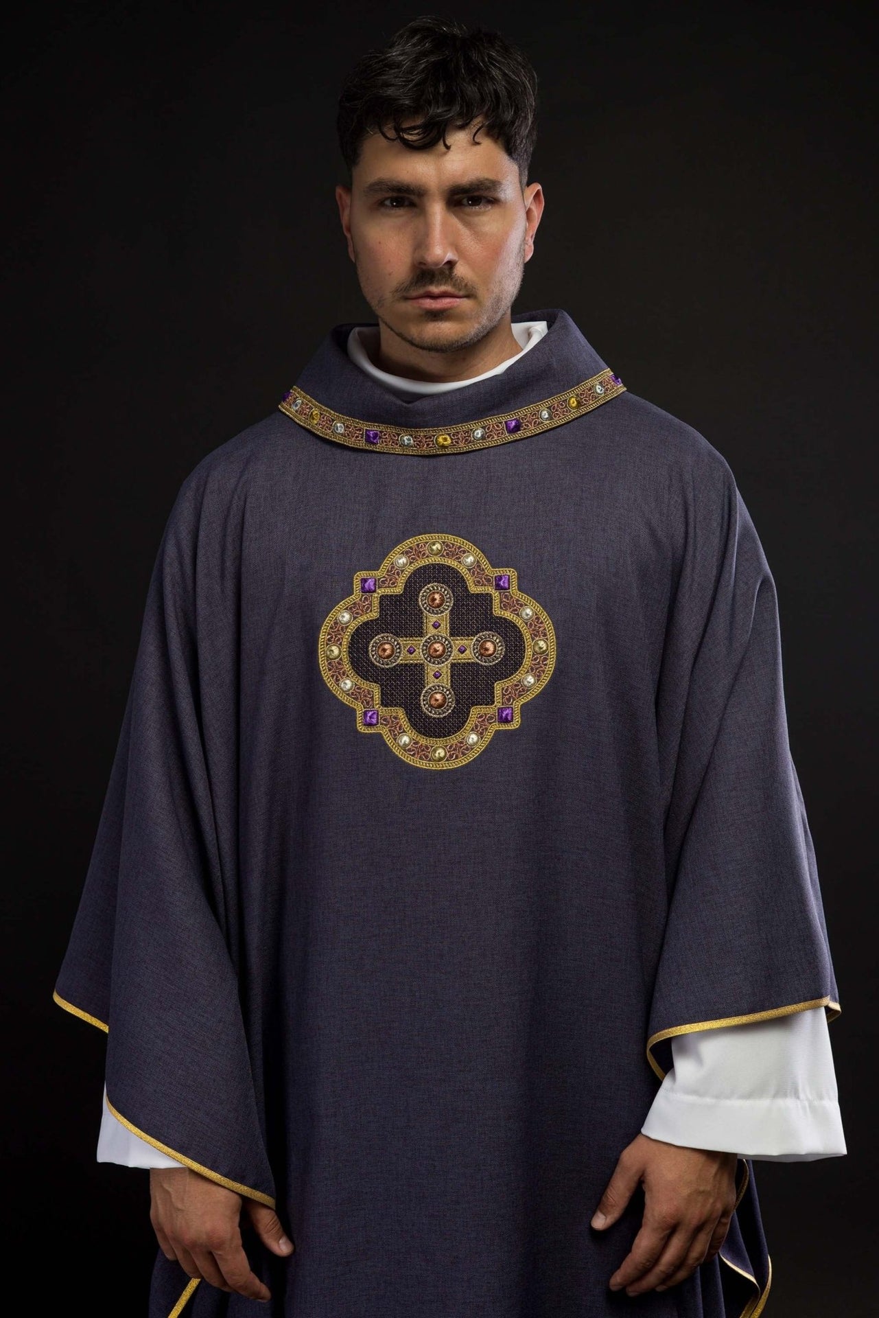 Ornat w kolorze fioletowym z haftowaną lamówką na kołnierzu i wokół haftu krzyża