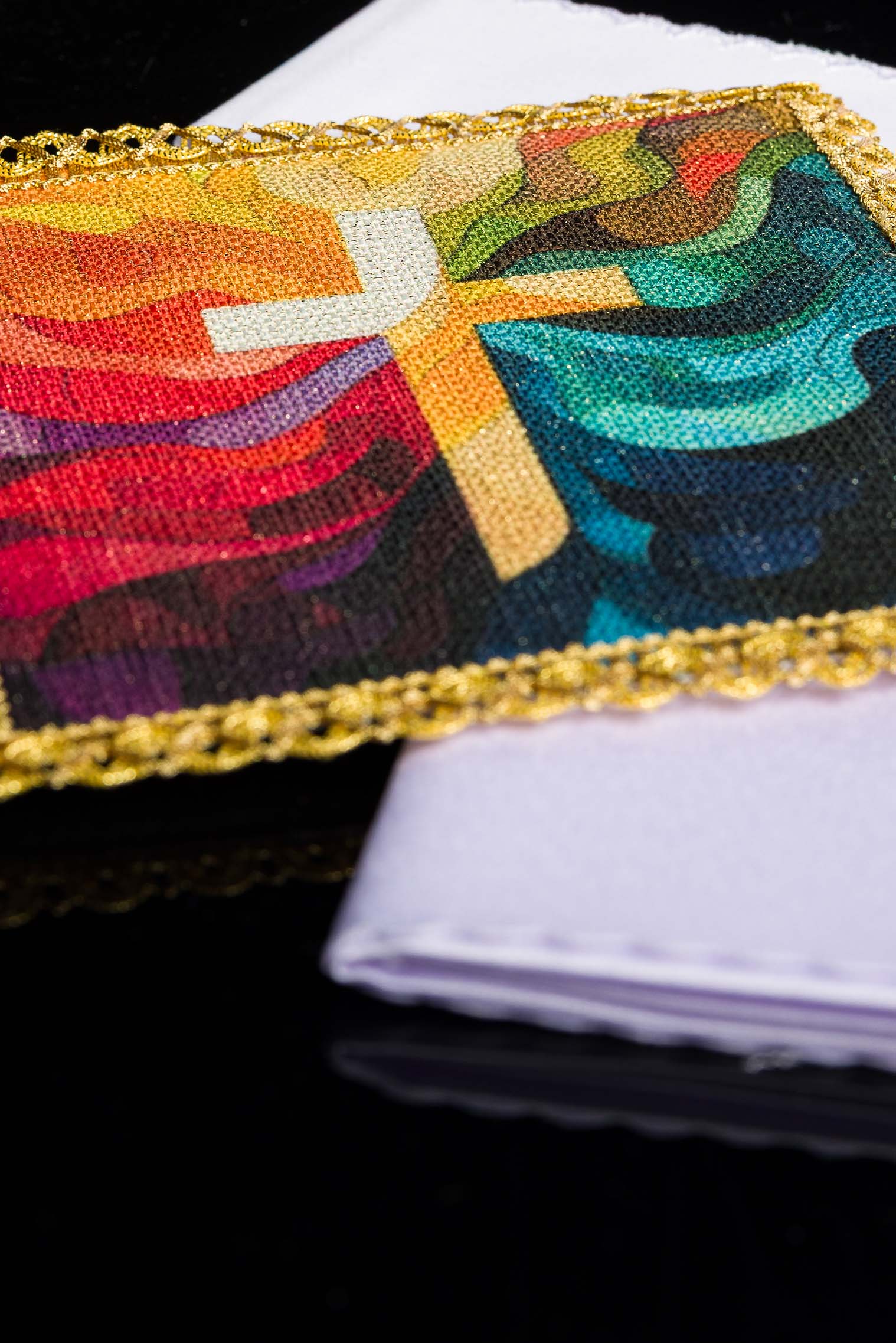 Close-up of the pall with printed multicolour cross and decorative gold braid edging